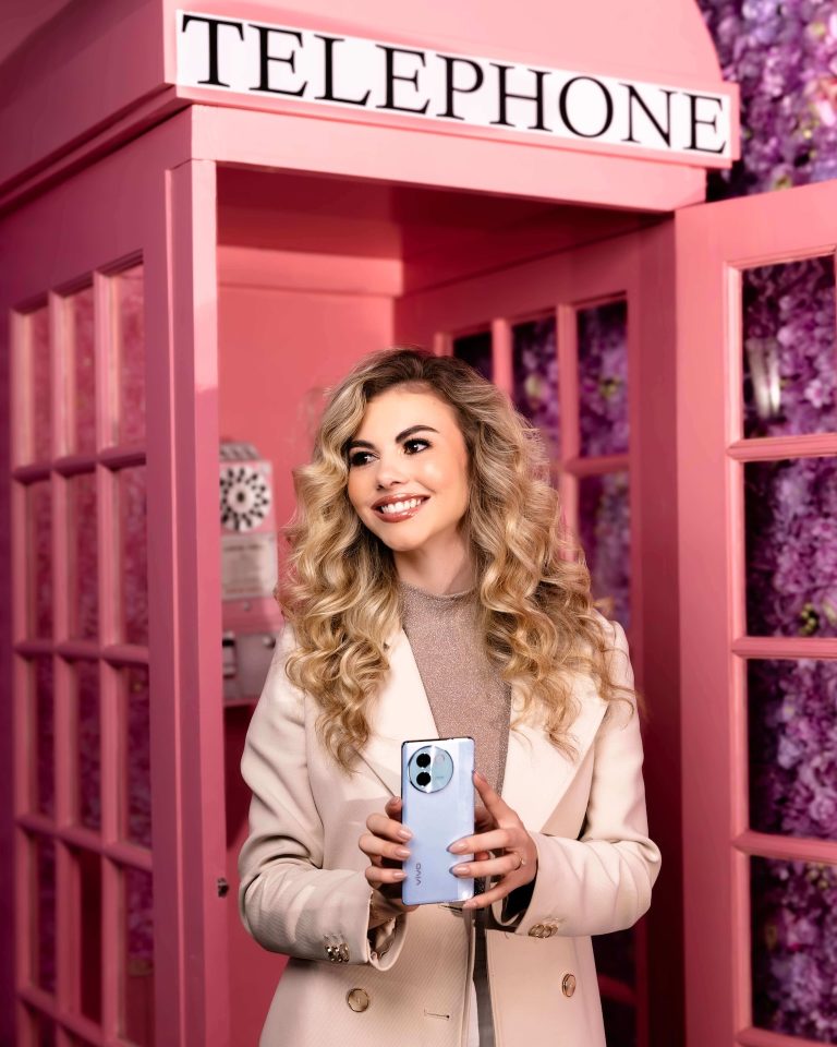 Model with a vivo smartphone in a pink telephone booth, photographed by Indirect Media