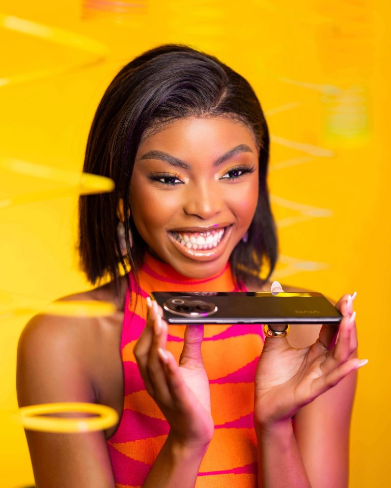 Model holding a vivo smartphone on a yellow set, photographed by Indirect Media